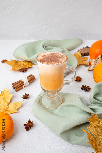 Pumpkin latte with whipped cream and spices on white background. Copy space.