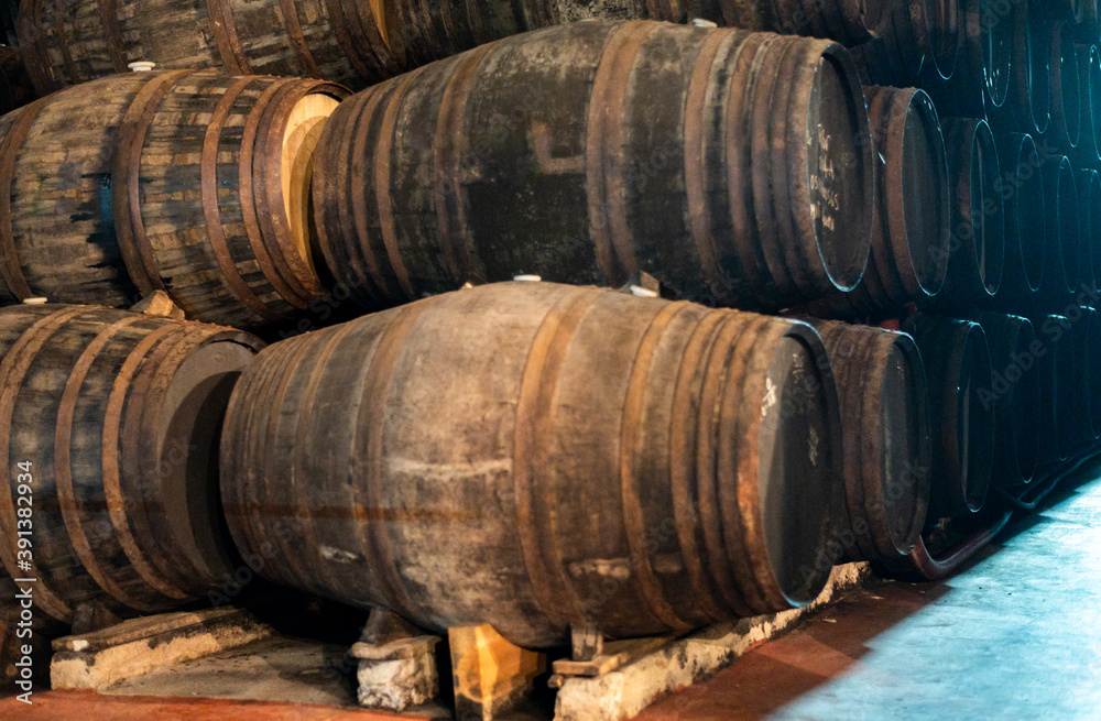 Old porto lodge with rows of oak wooden casks for slow aging of fortified ruby or tawny porto wine in Vila Nova de Gaia, Portugal Old porto lodge with rows of oak wooden casks for slow aging of fortified ruby or tawny porto wine in Vila Nova de Gaia, Portugal