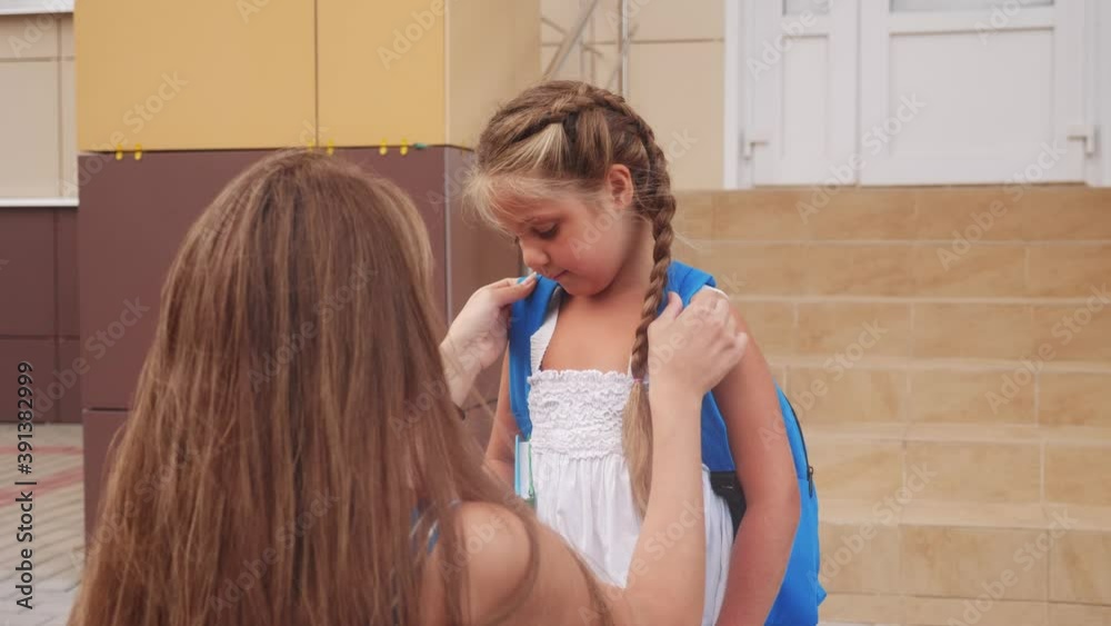 mom escorts her little daughter to school. happy family kid dream school concept. schoolgirl hurrying class for lesson to school. kid and mom goodbye lifestyle before school