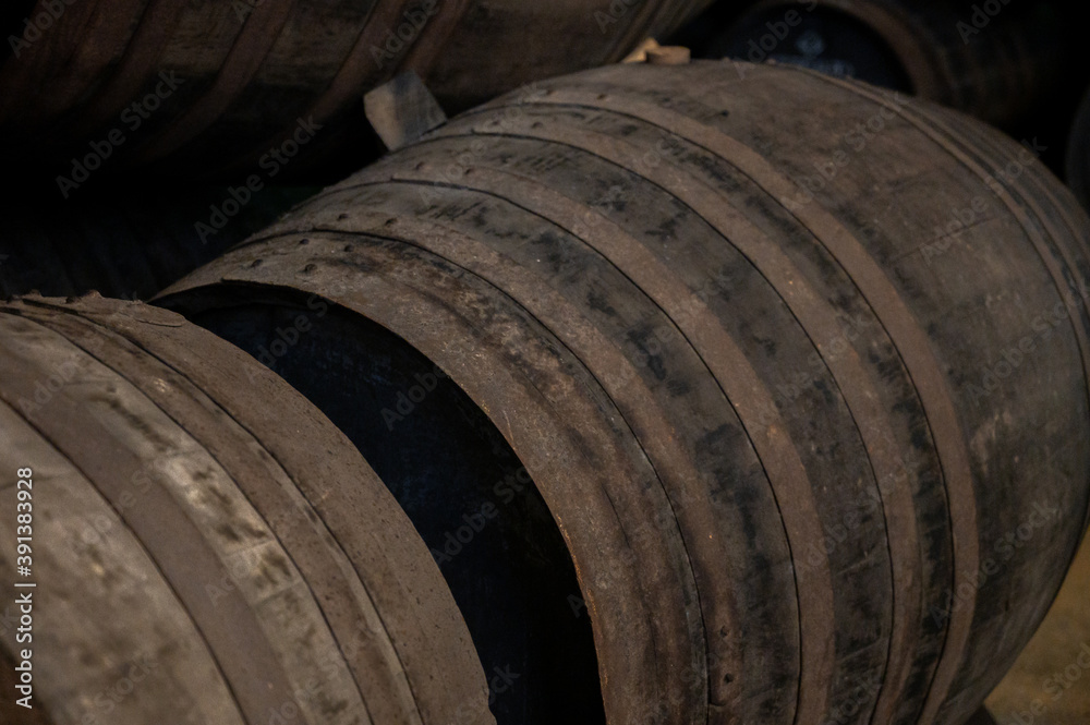 Old porto lodge with rows of oak wooden casks for slow aging of fortified ruby or tawny porto wine in Vila Nova de Gaia, Portugal Old porto lodge with rows of oak wooden casks for slow aging of fortified ruby or tawny porto wine in Vila Nova de Gaia, Portugal