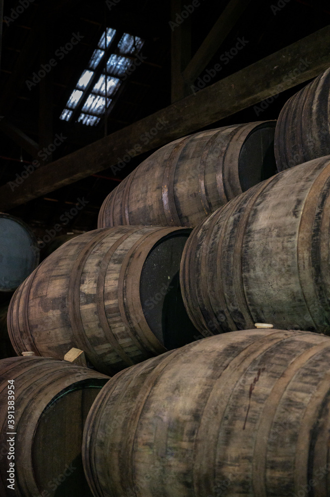 Old porto lodge with rows of oak wooden casks for slow aging of fortified ruby or tawny porto wine in Vila Nova de Gaia, Portugal Old porto lodge with rows of oak wooden casks for slow aging of fortified ruby or tawny porto wine in Vila Nova de Gaia, Portugal