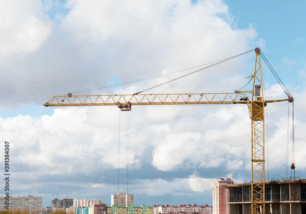 Construction crane in the beautiful clouds, blue sky and city.