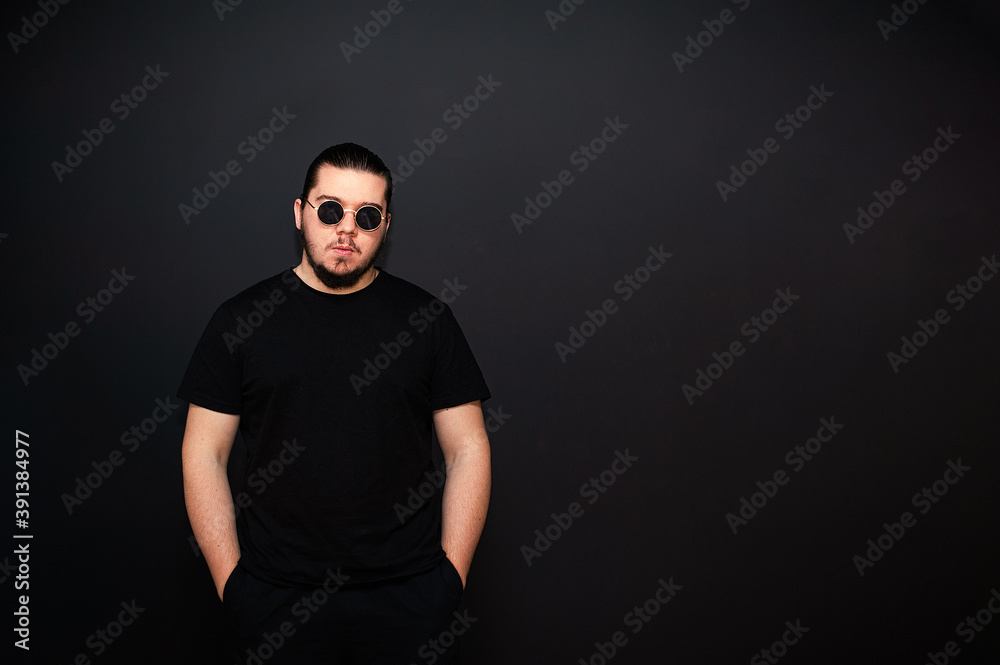 Obraz premium Young man on a background of black walls