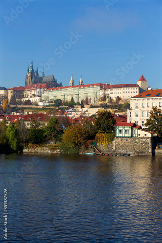 Autumn colorful Prague Lesser Town with gothic Castle above River Vltava in the sunny Day, Czech Republic