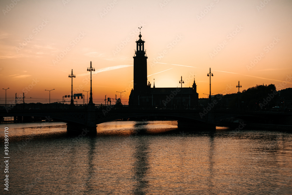 Beautiful view of the Stockholm City Hall during sunrise. Contrasting dark silhouette against the orange sky. Stockholm, Sweden 