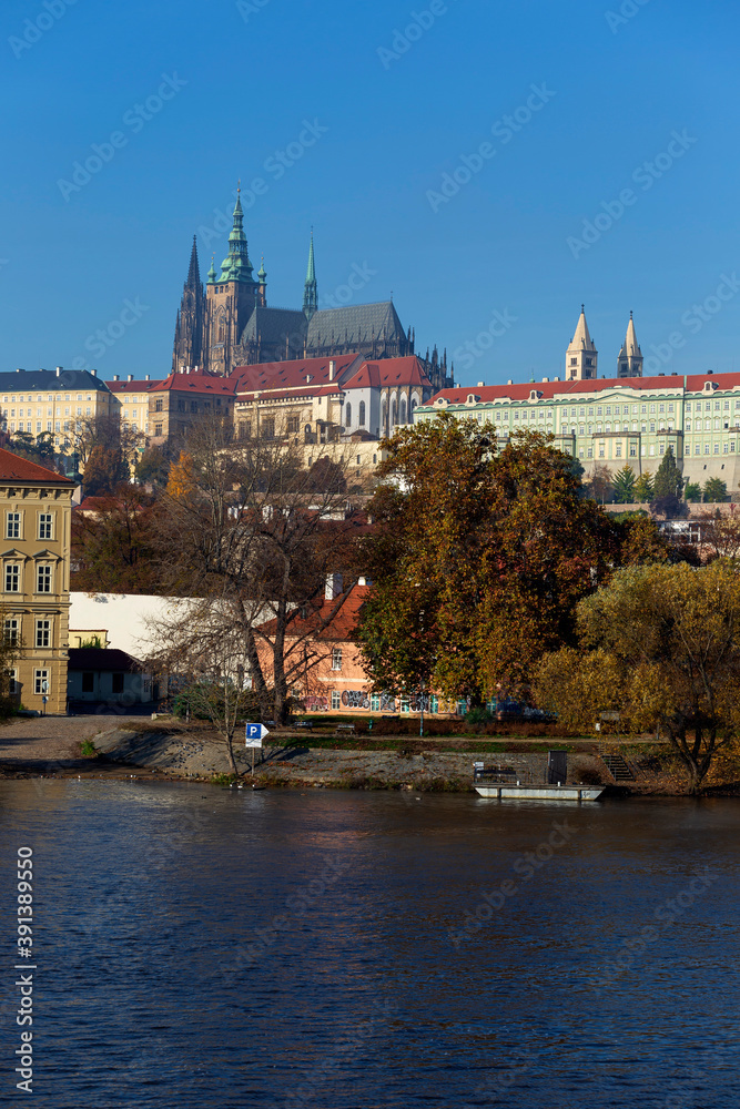 Obraz premium Autumn colorful Prague Lesser Town with gothic Castle above River Vltava in the sunny Day, Czech Republic