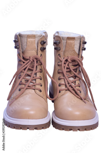 Two beige winter boots stand toes first on a white clipping background.