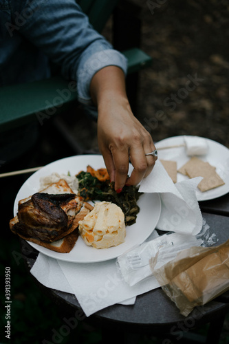 Woman eating barbecue at outdoor kickback