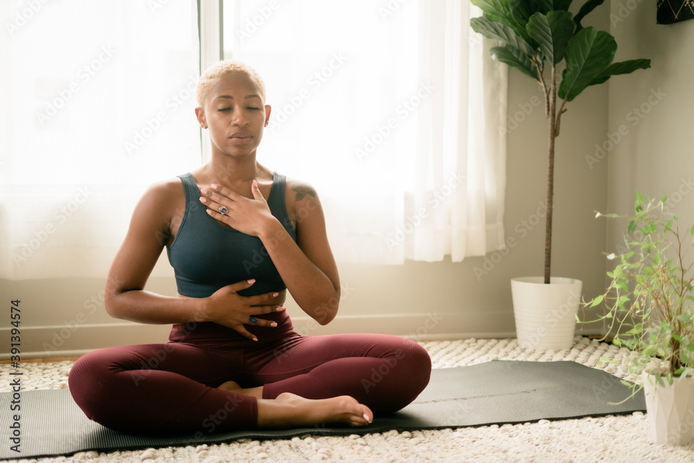 Black woman breathing and doing meditation at home Black woman breathing and doing meditation at home