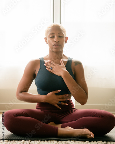 Black woman breathing and doing meditation at home