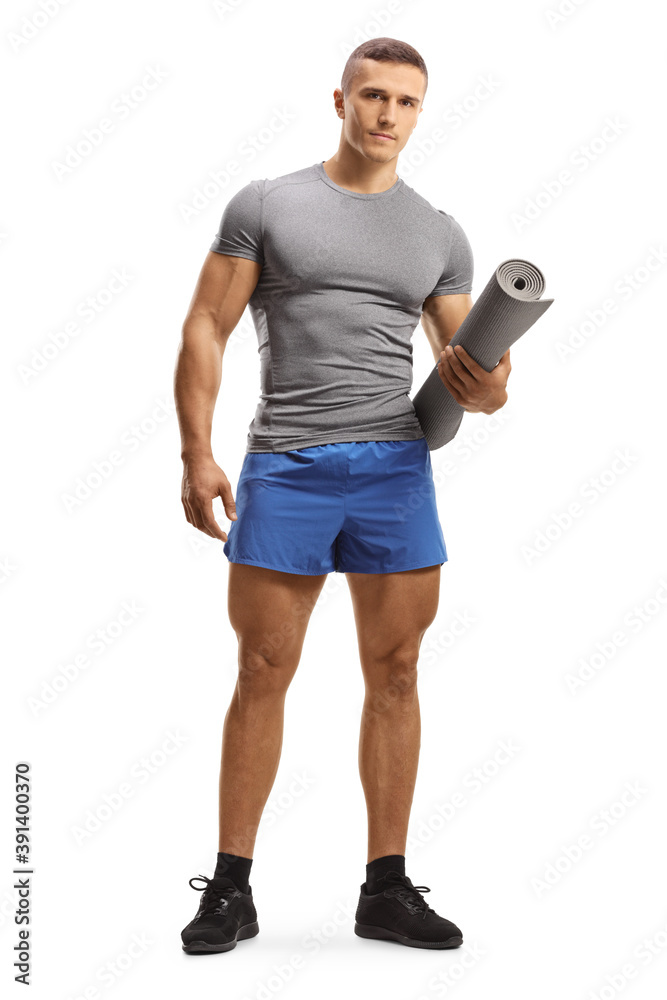 Full length portrait of a young fit man in sportswear holding an exercise mat Full length portrait of a young fit man in sportswear holding an exercise mat