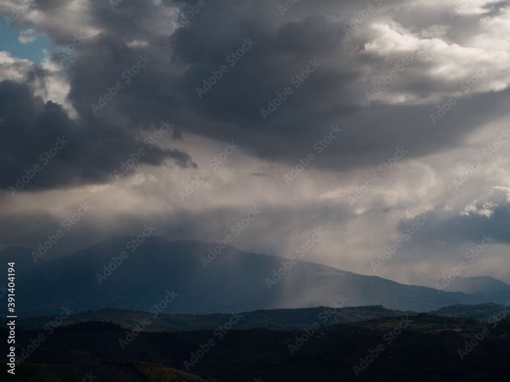 Cime dei monti Appennini avvolte da grandi nuvole nere con pioggia e foschia in una giornata invernale