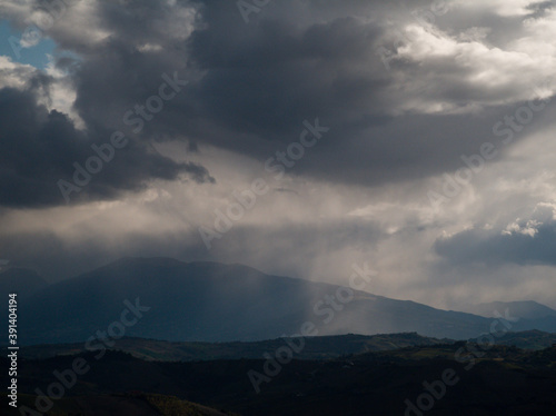 Cime dei monti Appennini avvolte da grandi nuvole nere con pioggia e foschia in una giornata invernale