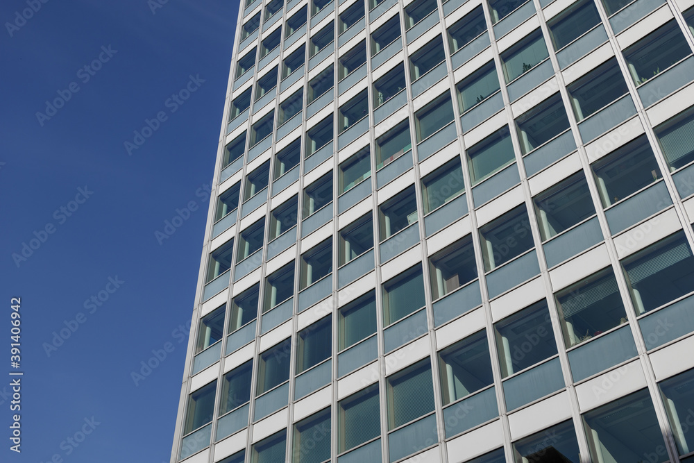 Low angle view of glass facade with rectangular windows frame structure system of modern style office building. Abstract Architectural Geometry elements. Mood of urban metropolis concept. Low angle view of glass facade with rectangular windows frame structure system of modern style office building. Abstract Architectural Geometry elements. Mood of urban metropolis concept.
