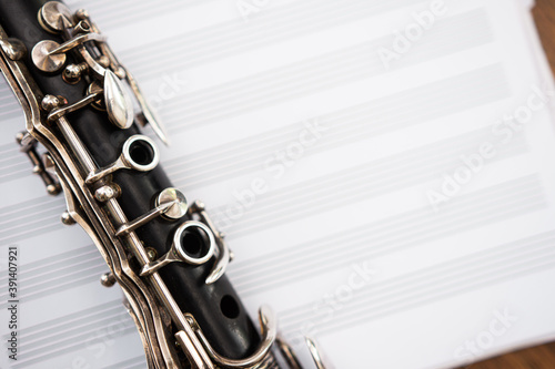 Slika na platnu Closeup of clarinet keys against blurry staff paper background