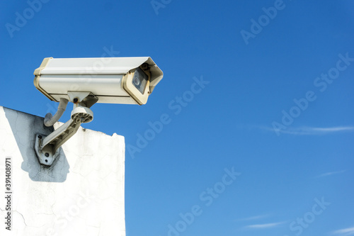 CCTV camera systems on a wall with copy space on blue sky on background. Concept of security, surveillance and monitoring.