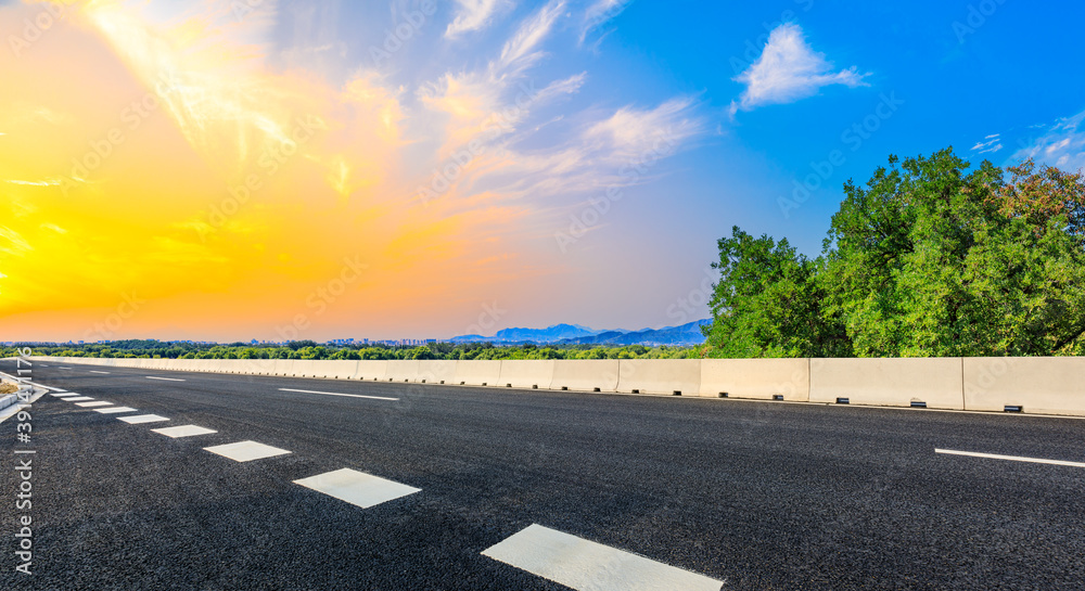 Fototapeta premium New asphalt road and green tree with mountain landscape in the suburbs of the city.