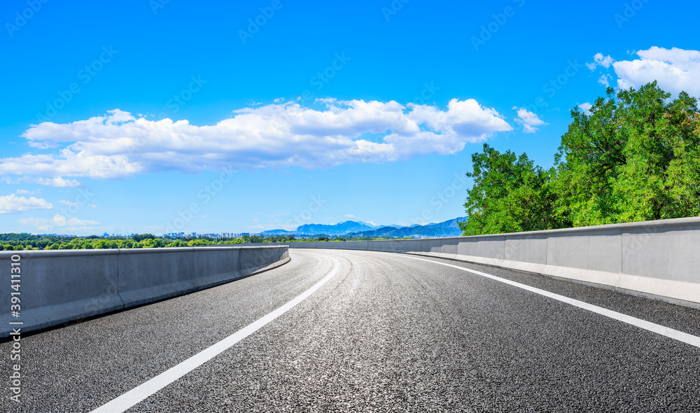 New asphalt road and green tree with mountain landscape in the suburbs of the city.