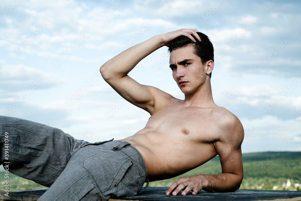 Strong man showing his perfect naked body outdoor. Bare torso. Strong man showing his perfect naked body outdoor. Bare torso.