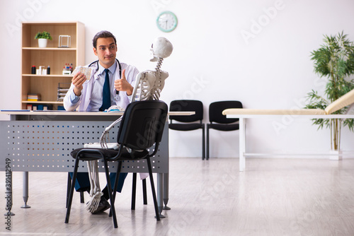 Young male doctor cardiologist and skeleton patient in the clini