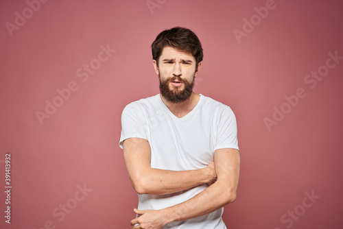 Man in white t-shirt emotions lifestyle facial expression cropped view pink background.