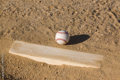 A baseball in the dirt at the pitchers mound.