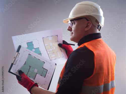 Man holds a house plan in h...
