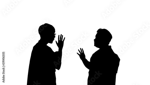 The silhouette of a man and woman talking in a serious conversation.