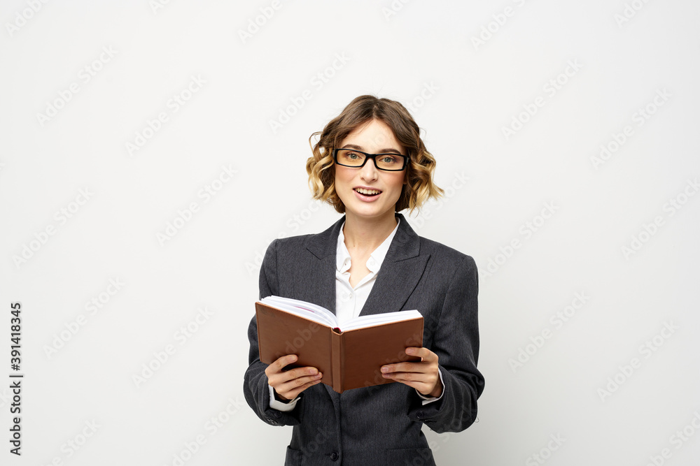 Business woman with notepad and glasses work light background cropped view of suit model. Business woman with notepad and glasses work light background cropped view of suit model.