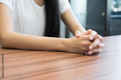 Close up woman hand on wooden table background.