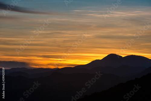 dramatic sunset landscape of the caribbean mountains of the dominican republic with orange clouds and blue sky.