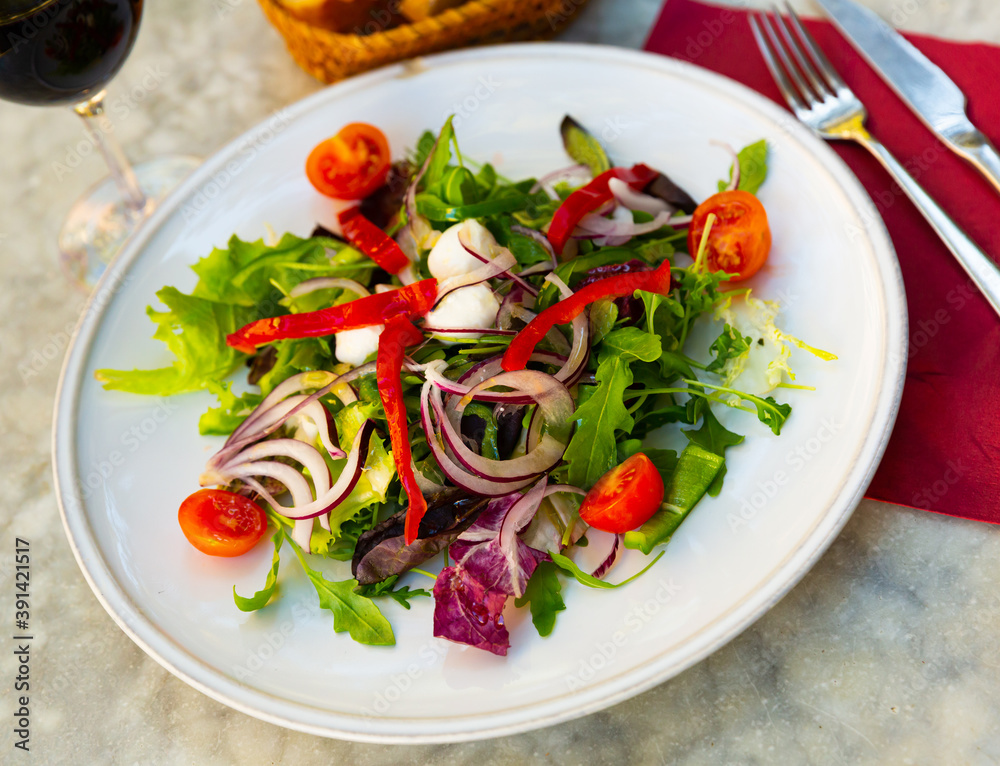 Delicious vegetable salad with cherry tomato, arugula, lettuce, bell pepper and mini mozzarella