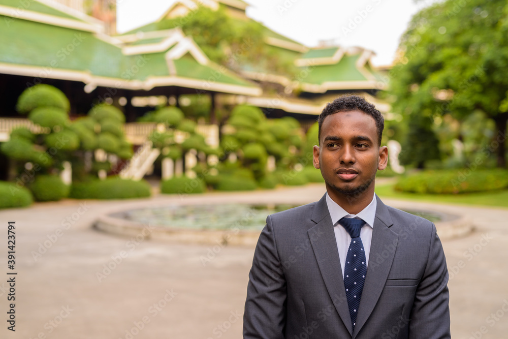 Portrait of young handsome African businessman thinking outdoors Portrait of young handsome African businessman thinking outdoors