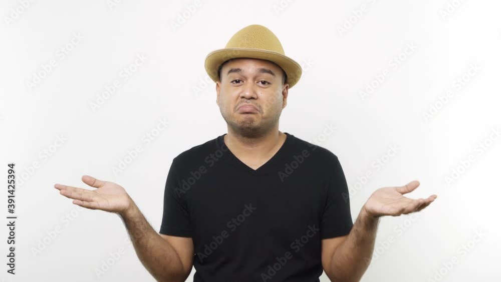 Guy put on hat in casual clothes expressing no and don't care gestures by shrugging shoulders with open hands and moving index finger on isolated white background. 4K Resolution. Guy put on hat in casual clothes expressing no and don't care gestures by shrugging shoulders with open hands and moving index finger on isolated white background. 4K Resolution.