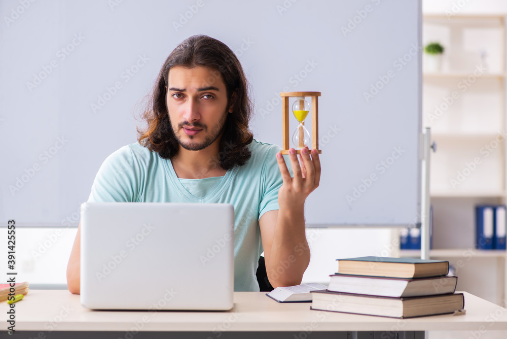 Young male student preparing for exams in time management concep Young male student preparing for exams in time management concep