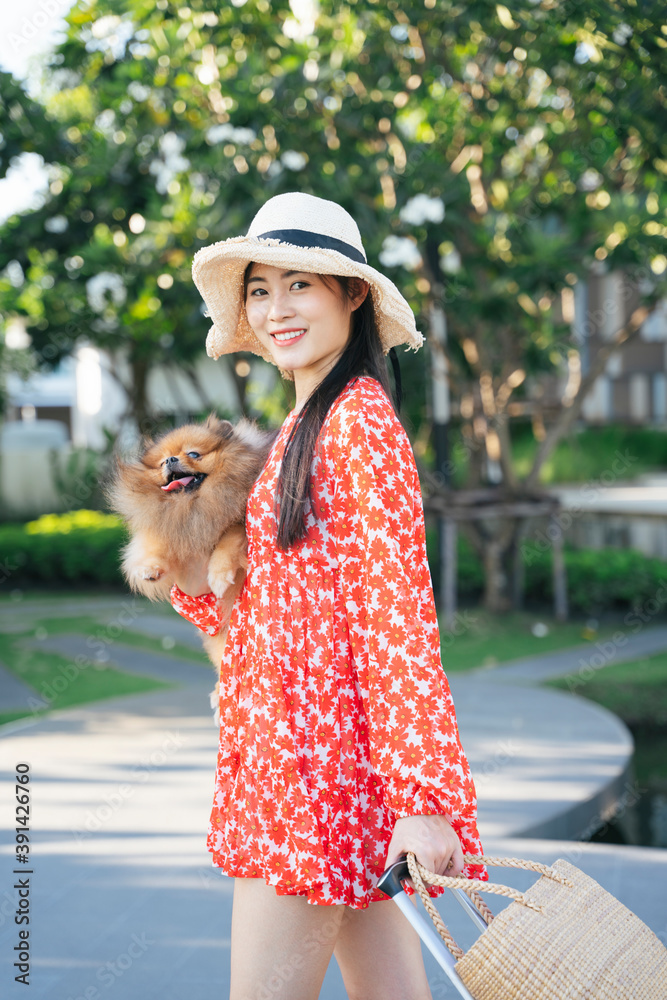 Beautiful asian traveler woman travel with her dog in resort.