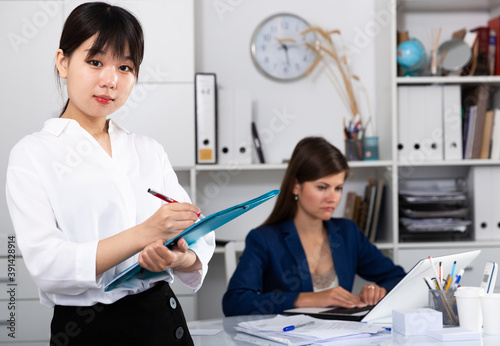 Portrait of successful confident chinese business woman in office interior. High quality photo