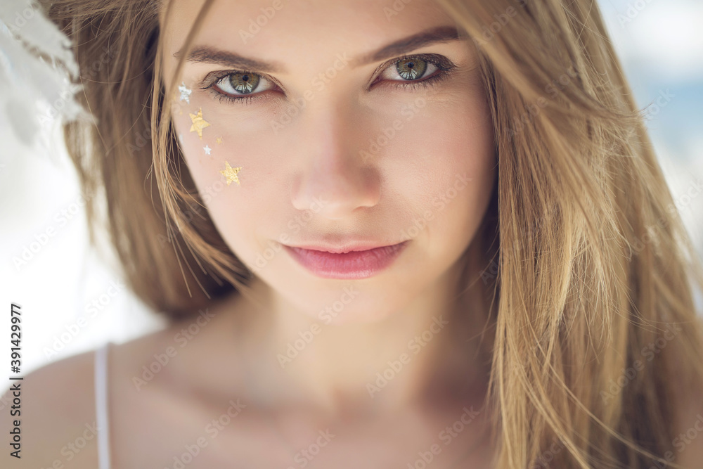 Attractive beauty woman face with star make up freckles. Portrait of a girl. High quality photo.