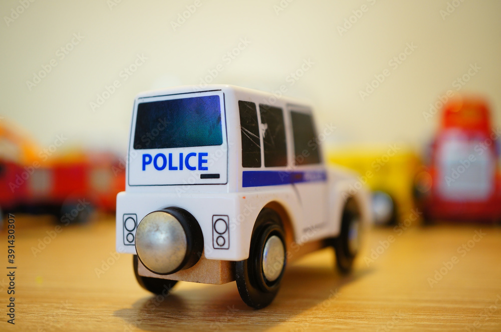 Φωτογραφία Closeup of a police car toy next to other toys on a blurry background