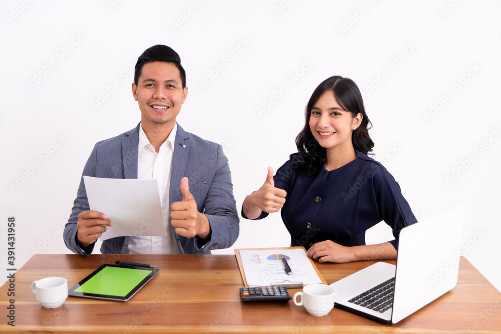 portrait of a business partner who is calculating his business profits and working on a laptop. Showing thumb on modern office desk portrait of a business partner who is calculating his business profits and working on a laptop. Showing thumb on modern office desk