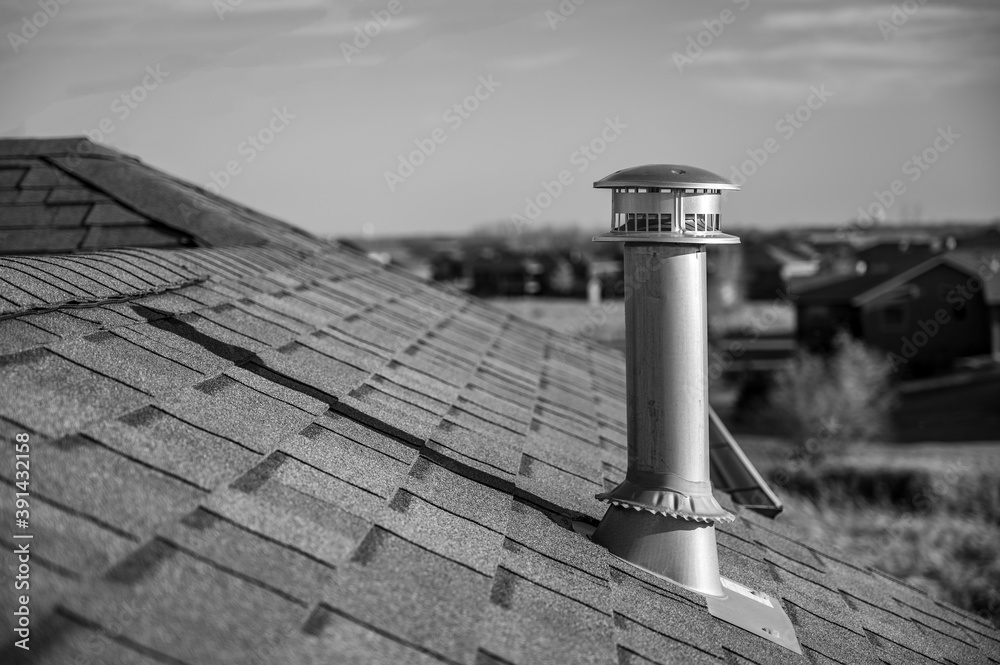 side view of a Galvanized metal chimney exhaust on asphalt roof with a