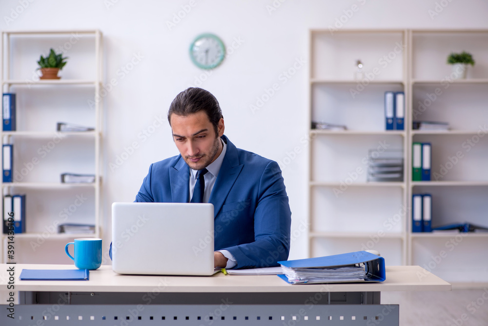 Young male employee working at workplace Young male employee working at workplace