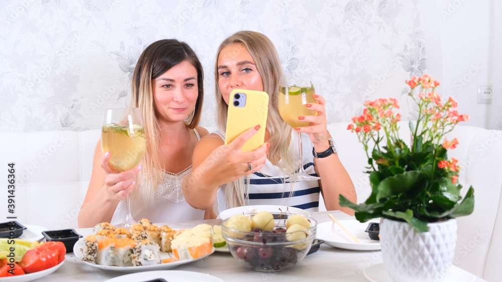 Two happy friends sharing online content using smartphone at home, selective focus Two happy friends sharing online content using smartphone at home, selective focus