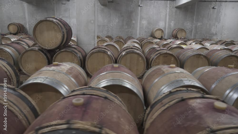A wine cellar full of wooden barrels to age red wine, French tradition A wine cellar full of wooden barrels to age red wine, French tradition