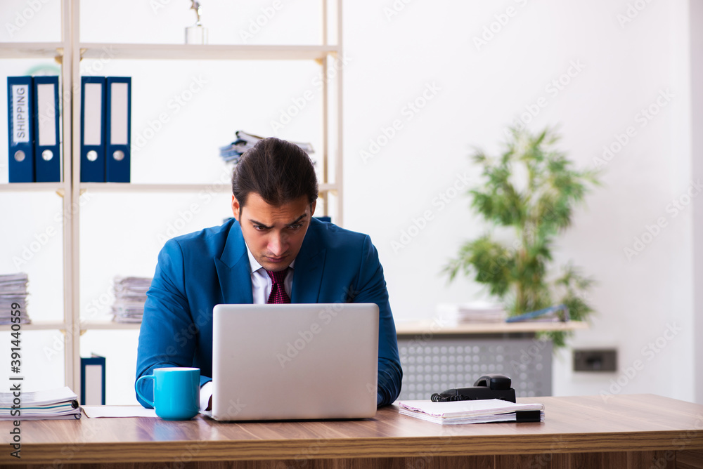 Fototapeta premium Young male employee working in the office