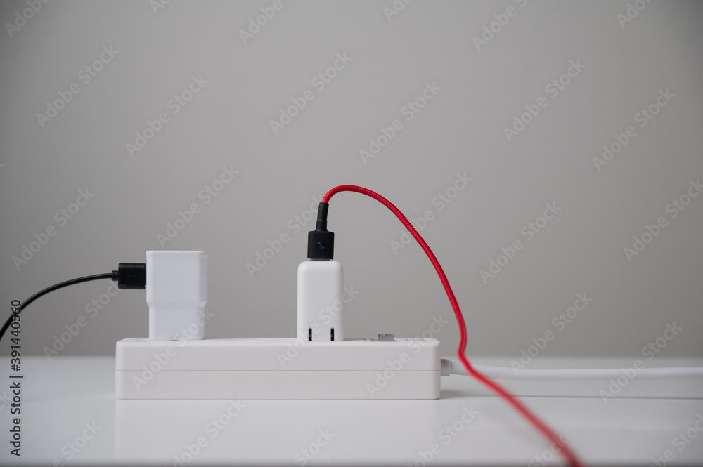 Electric adapter smartphone plug in multiple socket. Electrical equipment, electrical wires and power strips in the house. Earth Hour saving electrical energy. Electric adapter smartphone plug in multiple socket. Electrical equipment, electrical wires and power strips in the house. Earth Hour saving electrical energy.