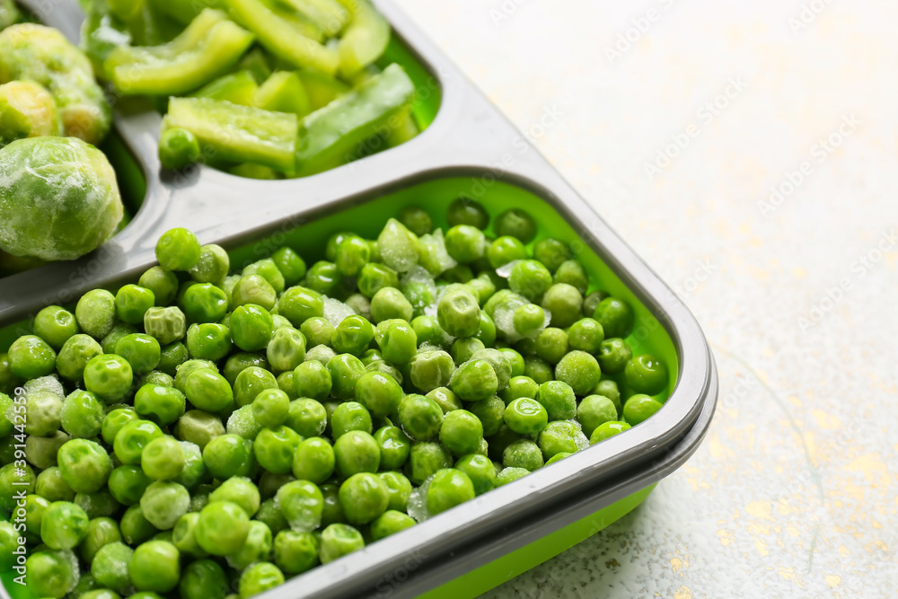 Divided box with different frozen vegetables on white background, closeup Divided box with different frozen vegetables on white background, closeup