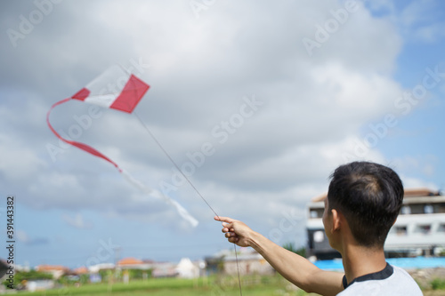 portrait of a young man playing a kite in a rice field