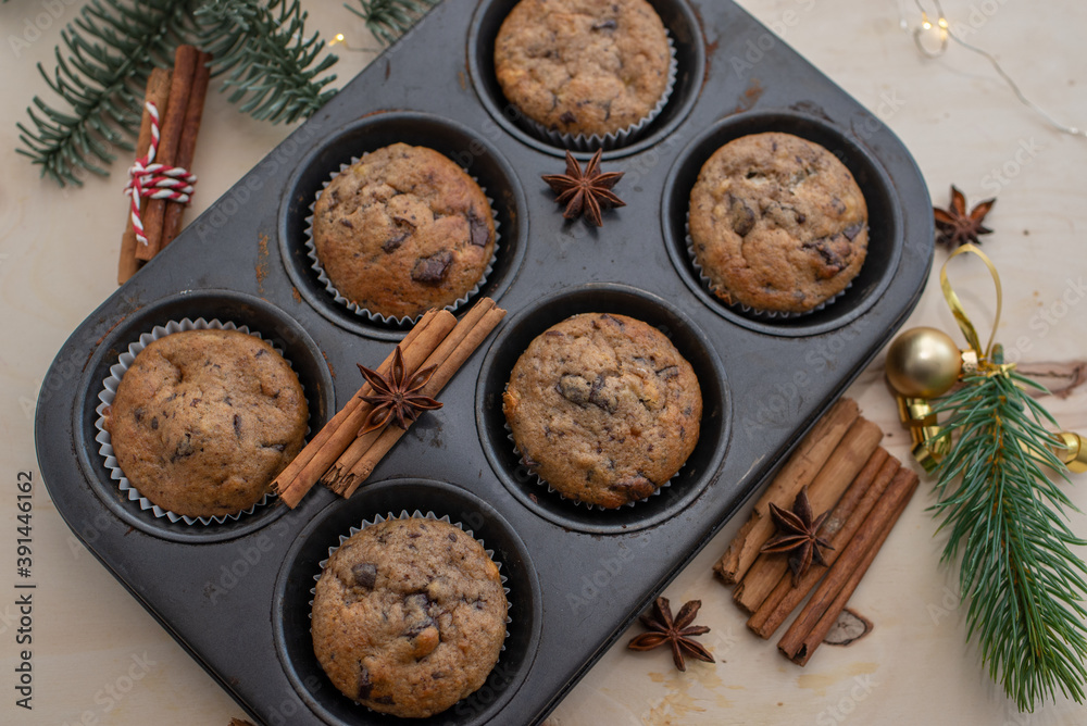 Fresh homemade gingerbread muffins in baking form on wooden table with Christmas decoration Fresh homemade gingerbread muffins in baking form on wooden table with Christmas decoration
