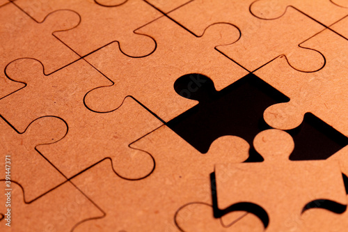 Close up view of a brown puzzle with one piece missing